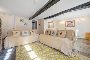 Habitació amb un llit, una panxa de fusta, un mirall i un quadre a la paret.