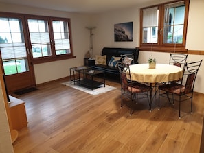 A dining area with a round table and chairs, a sofa, and a painting on the wall. - Nies Gagliner, (Falera), 42105 by Interhome (Falera)