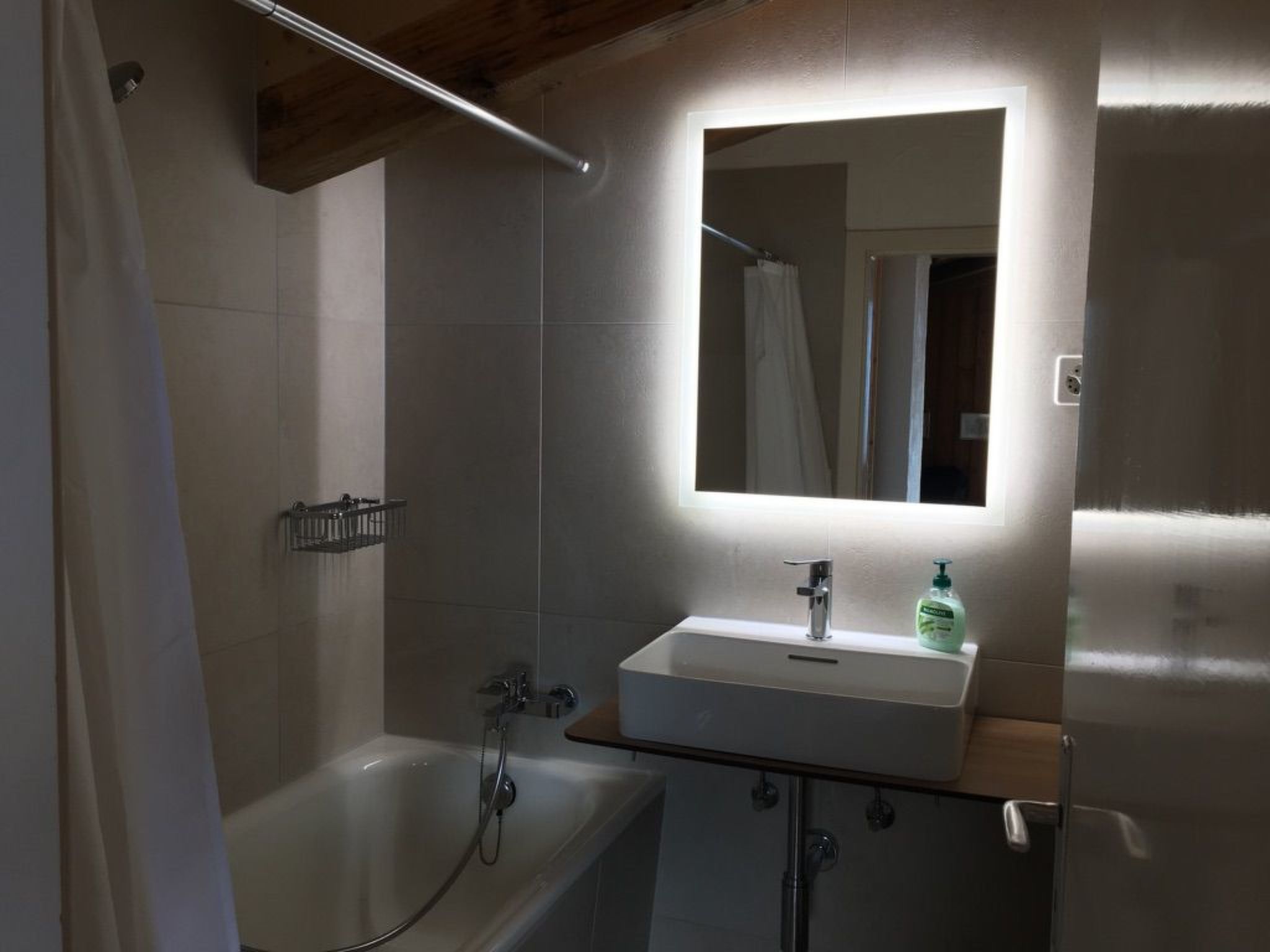 Une salle de bain avec une baignoire, un lavabo et un miroir.