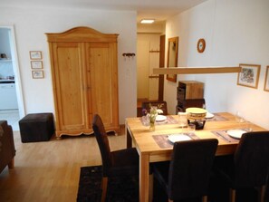 A dining area with a wooden table, chairs, a cabinet, and a clock on the wall. - Pignia 2 / Greulich, (Laax Dorf), 25223 by Interhome (Laax)