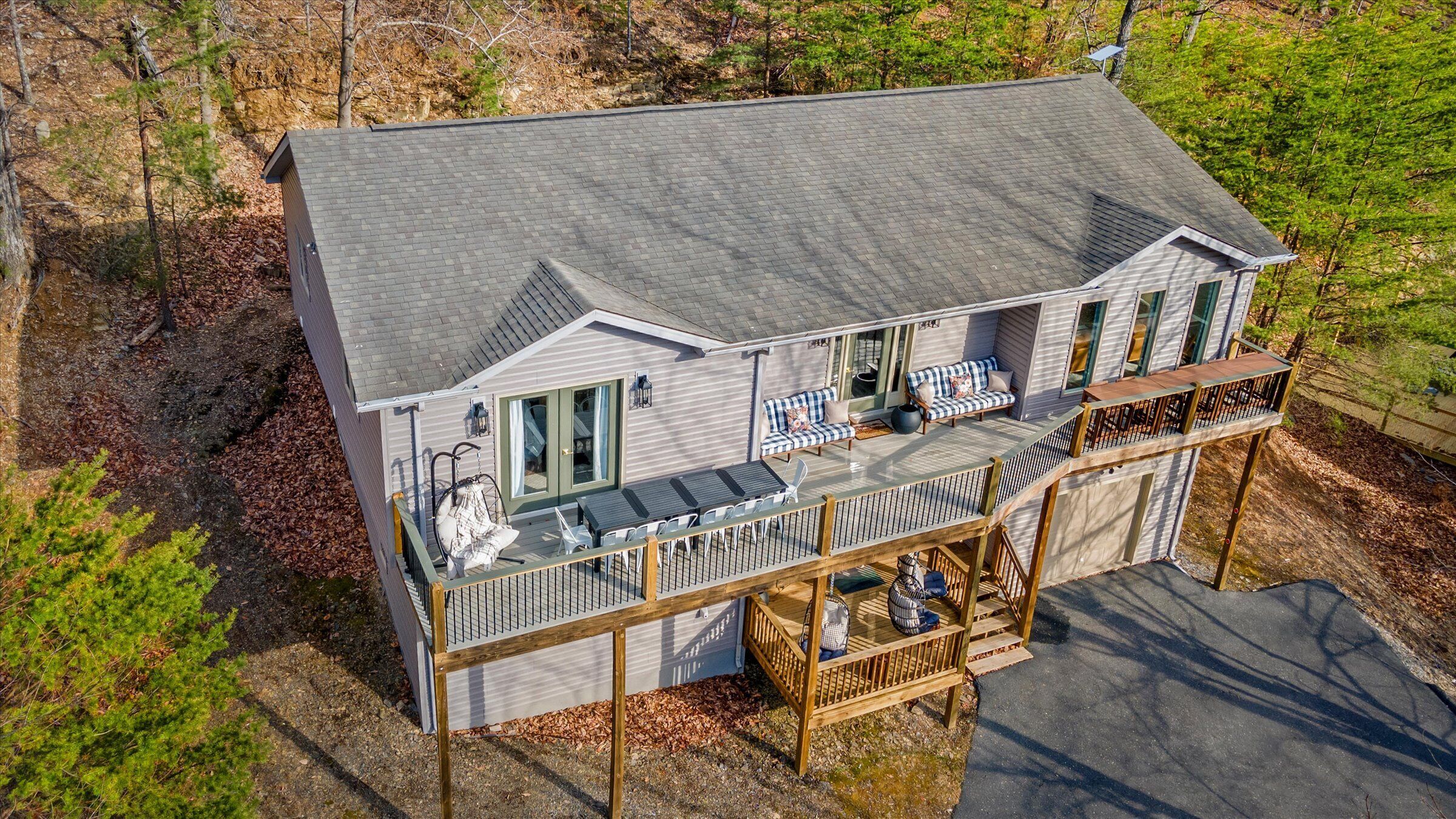 A two-story house with a balcony, a deck, and a patio area.
