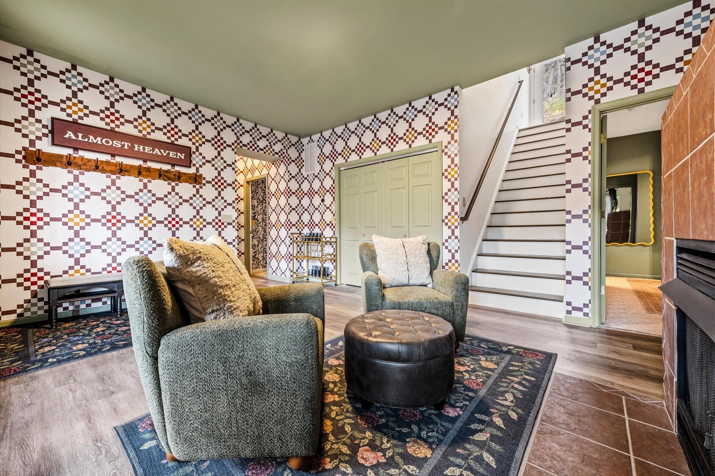 Un salon aux murs ornés de motifs, un escalier et une enseigne sur laquelle on peut lire : « Presque le paradis ».