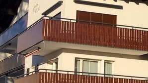 En toetagers bygning med en balkon på øverste etage og en garage på nederste etage.