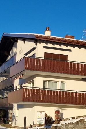 A two-story building with a balcony on the upper floor and a garage on the lower floor. - Casa Marcau, (Flims), by Interhome (Flims)
