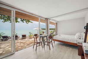 A modern bedroom with a large window, a bed, a table with chairs, and a view of the sea. - Room-charming Guest Room With Private Fa (Koh Samui)