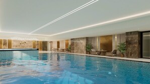 Ein Hallenbad mit Empfangsbereich, Sitzgelegenheiten und einer Wand mit einem Logo.