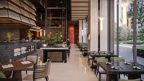 Ein modernes Restaurant mit einer langen Theke, Sitzbereich und großen Fenstern.