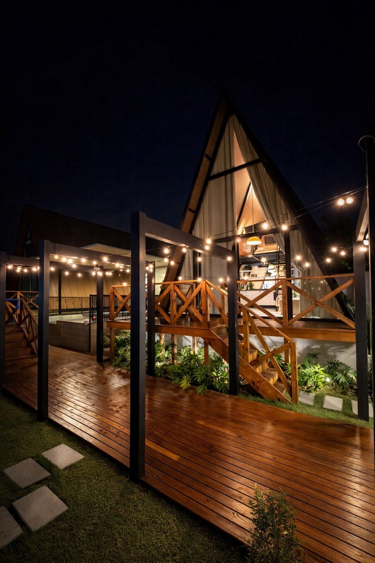 Espaço externo com iluminação charmosa e vista para a cabana, ideal para aproveitar a noite ao ar livre.