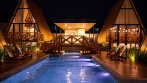 A pool area with two wooden structures, each with a balcony and seating. - Cabana com Piscina Aquecida e Spa (Palhoça)