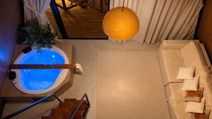 A spa area with a hot tub, a massage chair, and a staircase. - Cabana com Piscina Aquecida e Spa (Palhoça)
