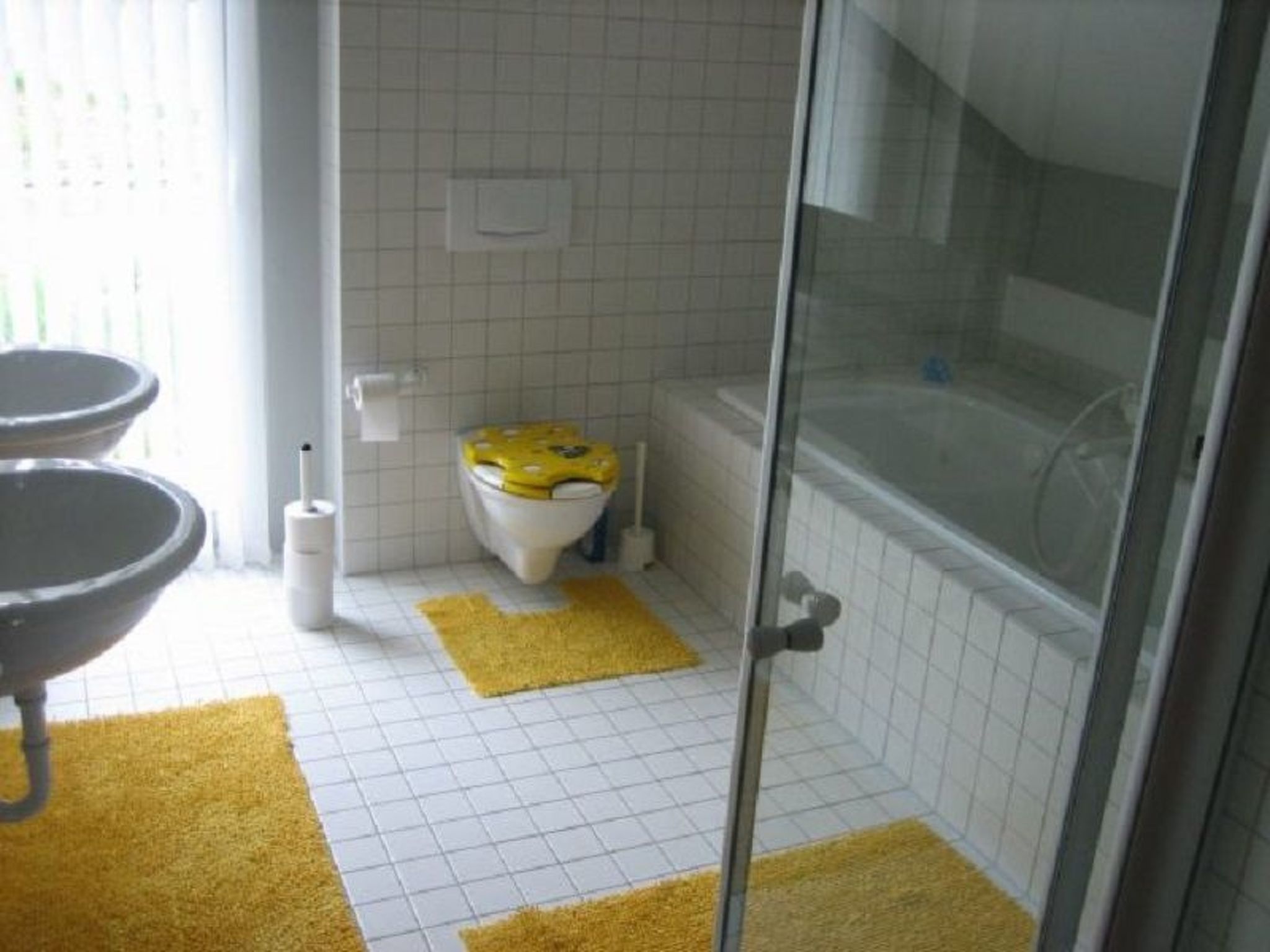 Une salle de bain comprenant des toilettes, un bidet et un espace douche.