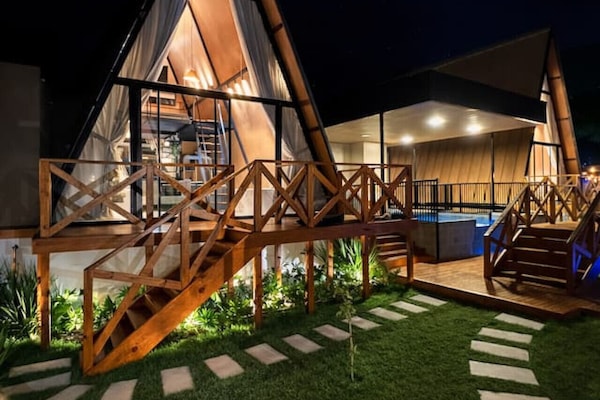 A Cabana Country da Vivendas Ferreira ganha um charme especial à noite. A iluminação quente valoriza cada detalhe da arquitetura em madeira, criando um cenário sofisticado e acolhedor.