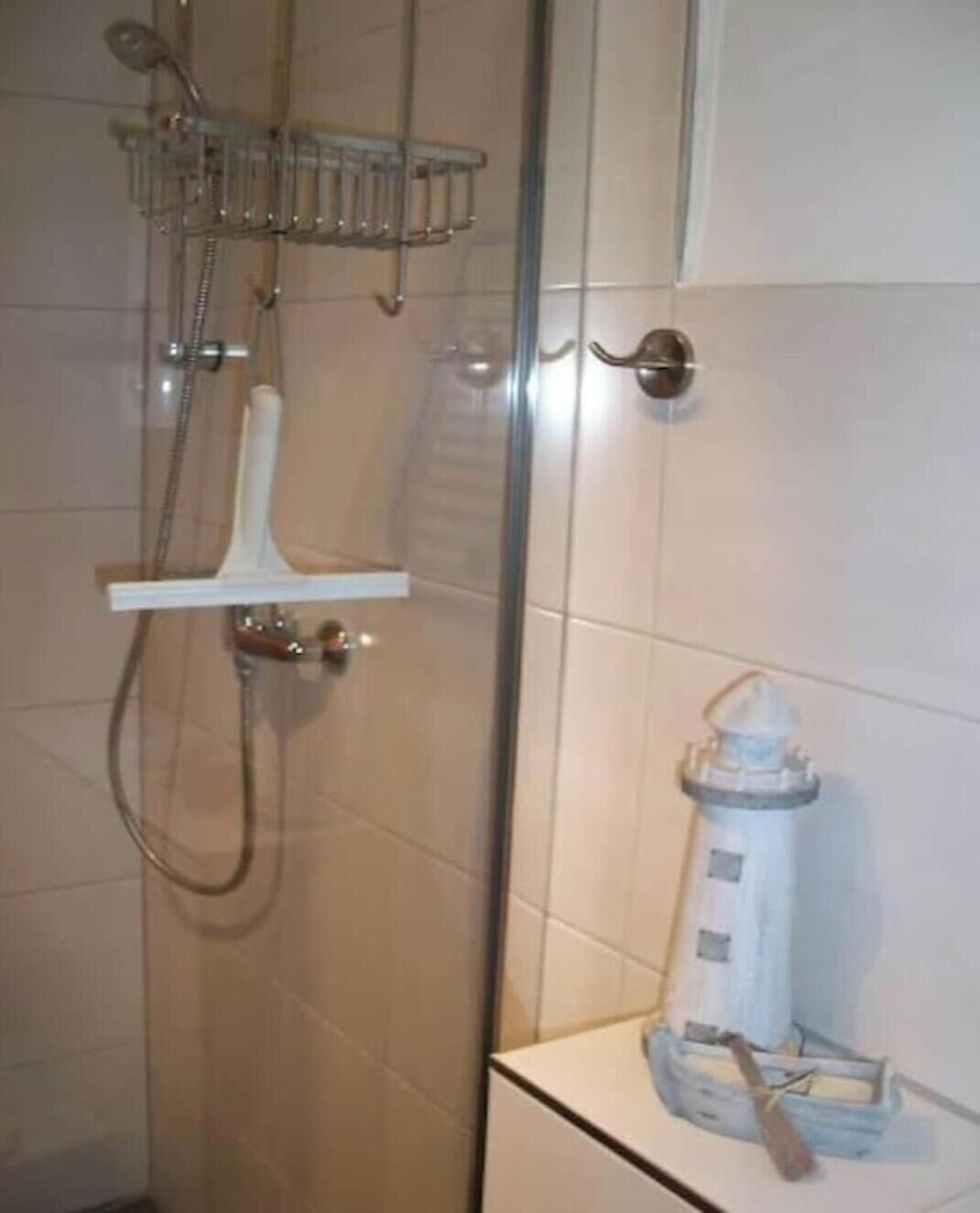 A bathroom with a shower, a towel rack, and a toilet.