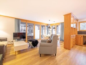 A spacious living room with a sofa, a television, and a dog. - Casa Radiras, (Laax Dorf), by Interhome (Laax)