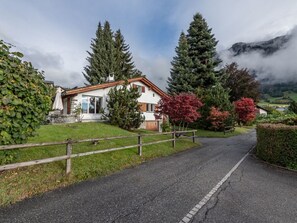Ein zweistöckiges Haus mit Steinunterbau, Holzfassade und geneigtem Dach.