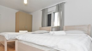 Makuuhuoneessa on yksi sänky, vaatekaappi ja ikkuna, jossa on verhot.