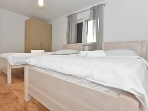 A bedroom with a single bed, a wardrobe, and a window with curtains. - Vacation home  by Interhome (Crno)