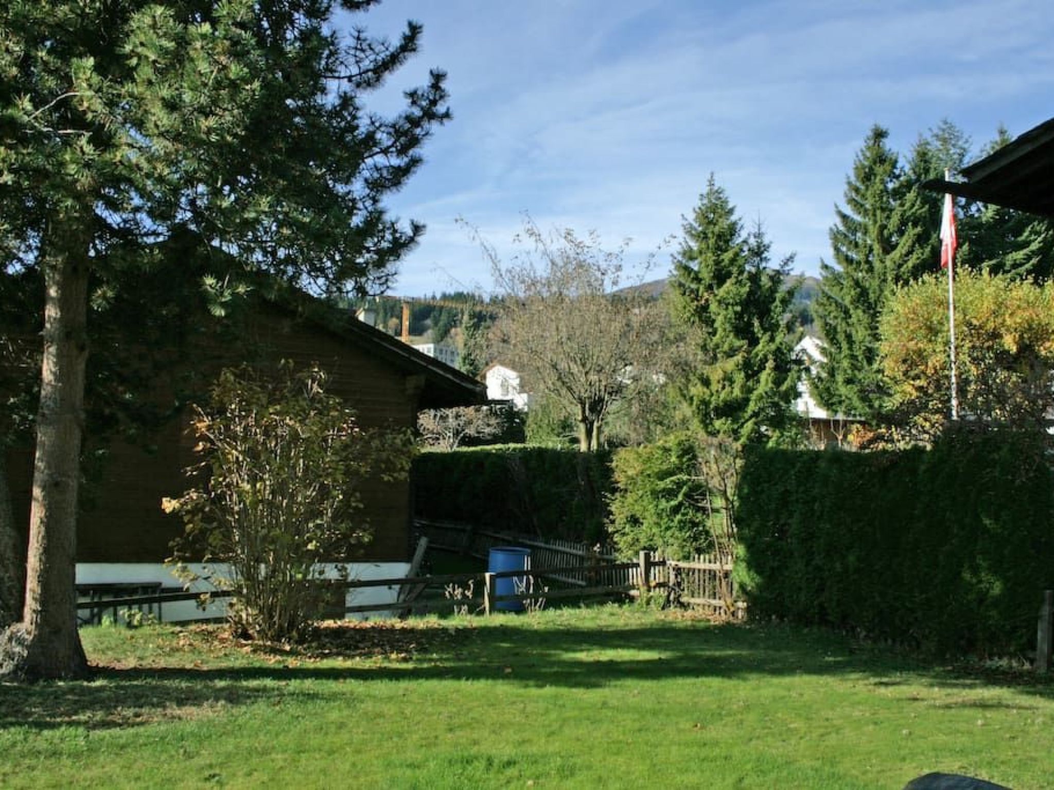 A residential area with a house, a small garden, and a wooden fence.