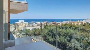 A balcony with a view of the sea and buildings. - Pembroke 2BR Sea View Walk to Beach & Town (Pembroke)