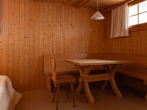 Un intérieur en bois avec un banc, une table et des chaises.