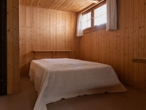 A small, single-bed room with wooden walls and a sloped ceiling. - Haus 3, (Laax Murschetg), 20914 by Interhome (Laax)