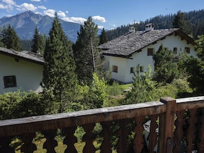 A mountain view with traditional buildings, a wooden fence, and dense forest. - Haus 3, (Laax Murschetg), 20914 by Interhome (Laax)