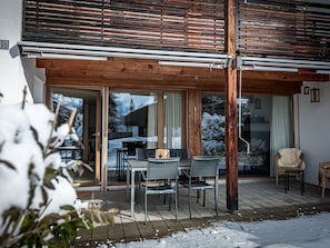 An outdoor patio with a wooden pergola, a table with chairs, and a view of a snowy landscape. - Prada 2, (Flims Dorf), by Interhome (Flims)