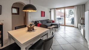 Un salon moderne avec une table à manger, un canapé et une vue sur l’extérieur.