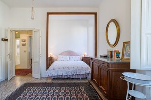 A bedroom with a bed, bedside lamps, a wooden dresser, a mirror, and a small table. - A charming, detached, 200-square-meter period house on three levels, accommodating up to 10 people.The property is located in Gravedona e Uniti, a charming village on the northwest shore of Lake Como, known for its historic center and picturesque lakefro (Gravedona ed Uniti)