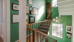 A staircase with wooden railings, green walls, and framed pictures. - A charming, detached, 200-square-meter period house on three levels, accommodating up to 10 people.The property is located in Gravedona e Uniti, a charming village on the northwest shore of Lake Como, known for its historic center and picturesque lakefro (Gravedona ed Uniti)