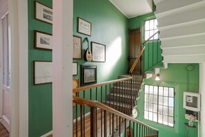 A staircase with wooden railings, green walls, and framed pictures. - A charming, detached, 200-square-meter period house on three levels, accommodating up to 10 people.The property is located in Gravedona e Uniti, a charming village on the northwest shore of Lake Como, known for its historic center and picturesque lakefro (Gravedona ed Uniti)