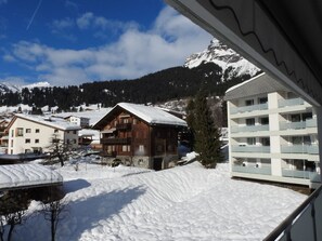 A snowy mountain village with wooden buildings and a modern hotel with balconies. - Ner B / Hartl, (Flims Dorf), 29 by Interhome (Flims)