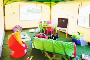 A child's playroom with a green play mat, a red chair, a small table, and a chalkboard. - 3-person holiday apartment with balcony (Debki)