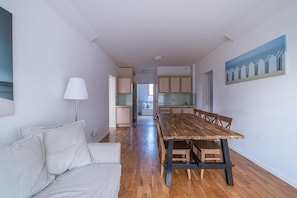 A spacious living area with a long wooden dining table, a sofa, and a lamp. - Large, comfortable apartment for 6 people (Debki)