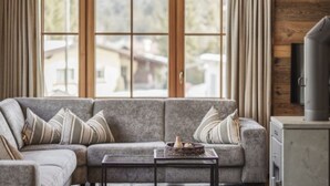 A living room with a sectional sofa, a coffee table, and a television on a cabinet.
