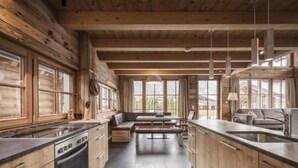 A log cabin interior with a kitchen, dining area, and seating.