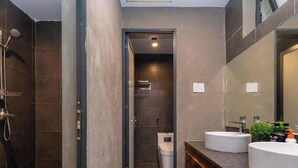 Ein modernes Badezimmer mit Dusche, zwei Waschbecken und einem Spiegel.