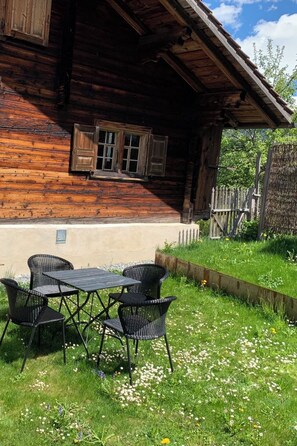 Une cabane en bois dotée d’un coin repas avec une table et des chaises.
