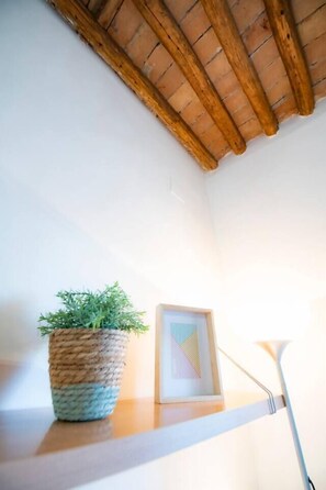 Ein Regal mit einem gewebten Blumentopf und einem gerahmten Bild.
