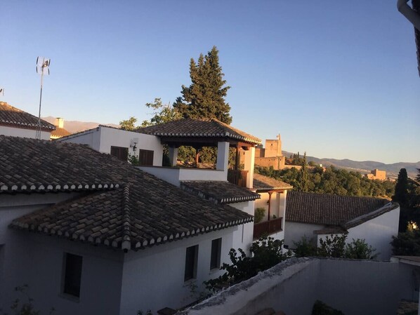 Ein Wohngebiet mit traditioneller Architektur, darunter Ziegeldächer und weiße Wände, mit freiem Blick auf die umliegende Landschaft.