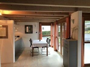 Un comedor con mesa, sillas y mostrador de cocina.