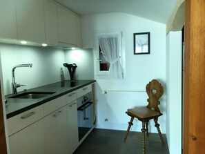 A compact kitchen with a sink, stove, and cabinets. - Casa Vesta Magnifica, Brigels, (Breil/Brigels), 65063B by Interhome (Breil/Brigels)