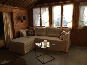 A cozy room with a sofa, a glass coffee table, and a lamp. - Casa Vesta Magnifica, Brigels, (Breil/Brigels), 65063B by Interhome (Breil/Brigels)