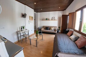 A modern living space with a dining area, a sofa, and a laptop on a glass table. - Studio with terrace and views of the Alhambra (Granada)