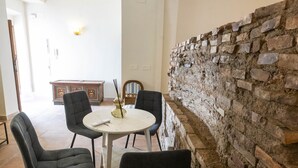 Ein Essbereich mit einem runden Tisch, vier Stühlen, einer Wand mit Dekoration und einer Steinwand.