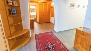 Un pasillo con estantes de madera, un tapete estampado y un mueble de madera.
