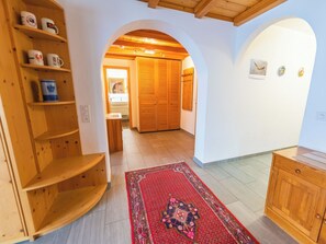 Ein Flur mit Holzböden, einem gemusterten Teppich und einem Holzschrank.