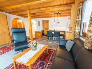 A cozy living room with a sofa, chairs, a coffee table, and a dining area with a table and chairs. - Casa Panorama Camartin, Brigels, (Breil/Brigels), 65037B by Interhome (Breil/Brigels)