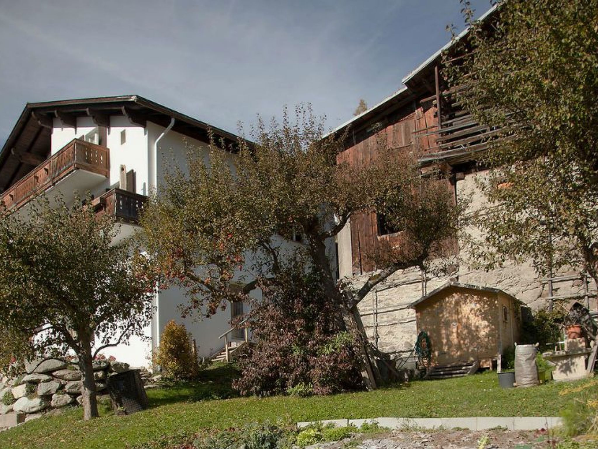 Ein traditionelles Chalet mit Natursteinfassade, Holzbalkonen und einem gepflegten Garten.