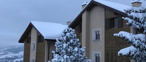 Un edificio de dos pisos con techo cubierto de nieve y un letrero que dice 'Jupiter'.